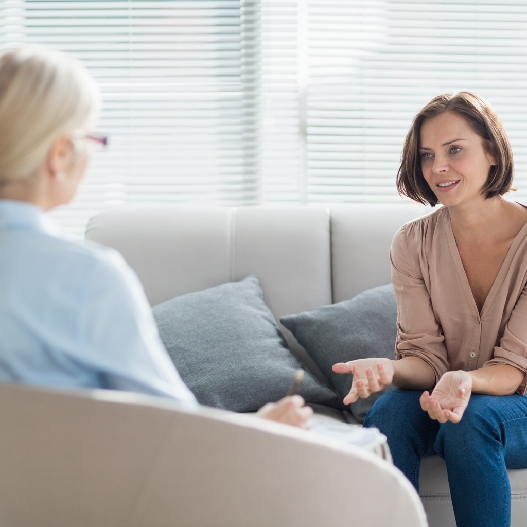 Woman talking to therapist on sofa at home